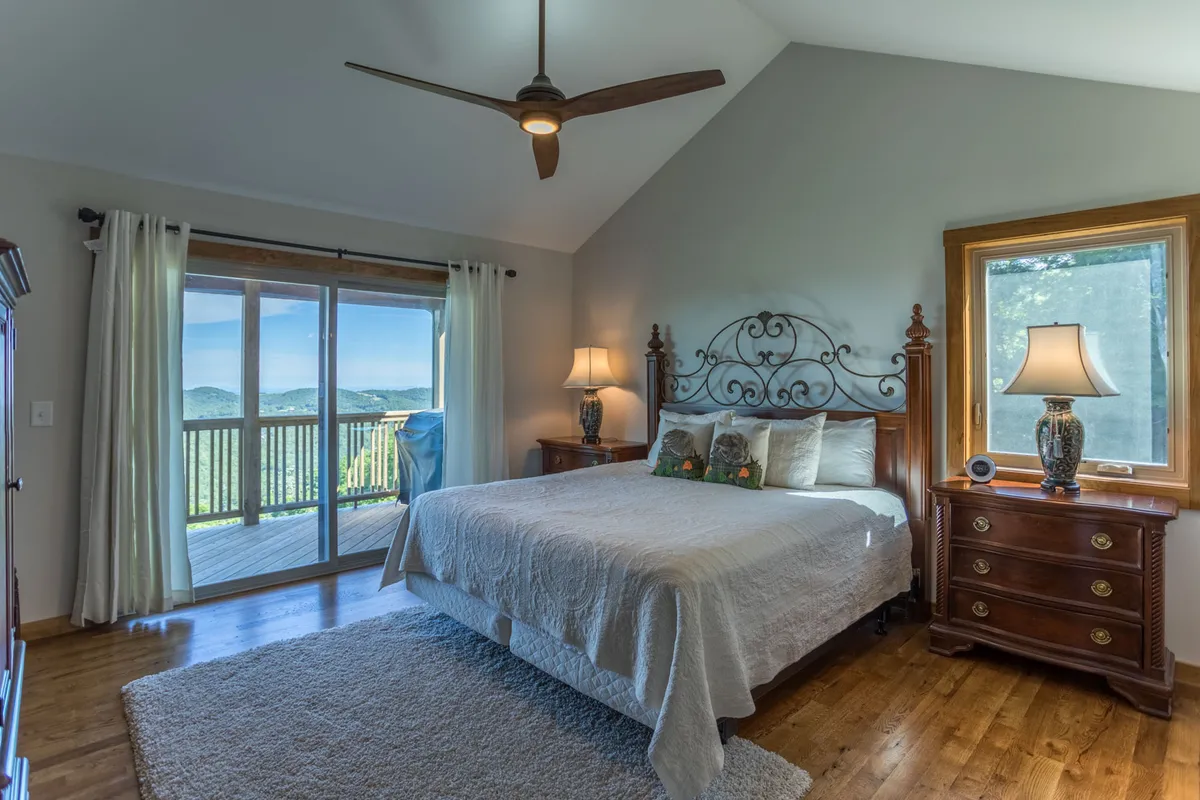 A serene bedroom scene featuring a plush bed with soft linens, a window offering tree-filled views, a nightstand with a lamp, and gentle natural light filling the room. The overall atmosphere exudes tranquility and restful comfort, perfect for relaxation and rejuvenation after a day of adventure.